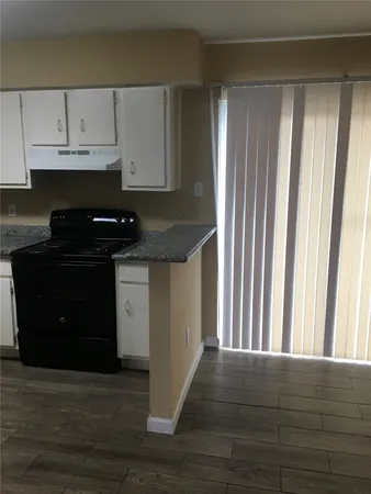 a kitchen with granite countertop a stove and a refrigerator