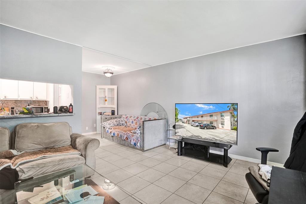 2915 Plunkett Street, Unit 5D Hollywood, FL 33020 - Photo 5 of 11 a living room with furniture and a painting on the wall