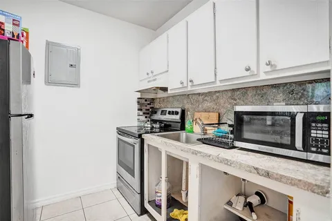 a kitchen with stainless steel appliances granite countertop a stove a microwave and a refrigerator