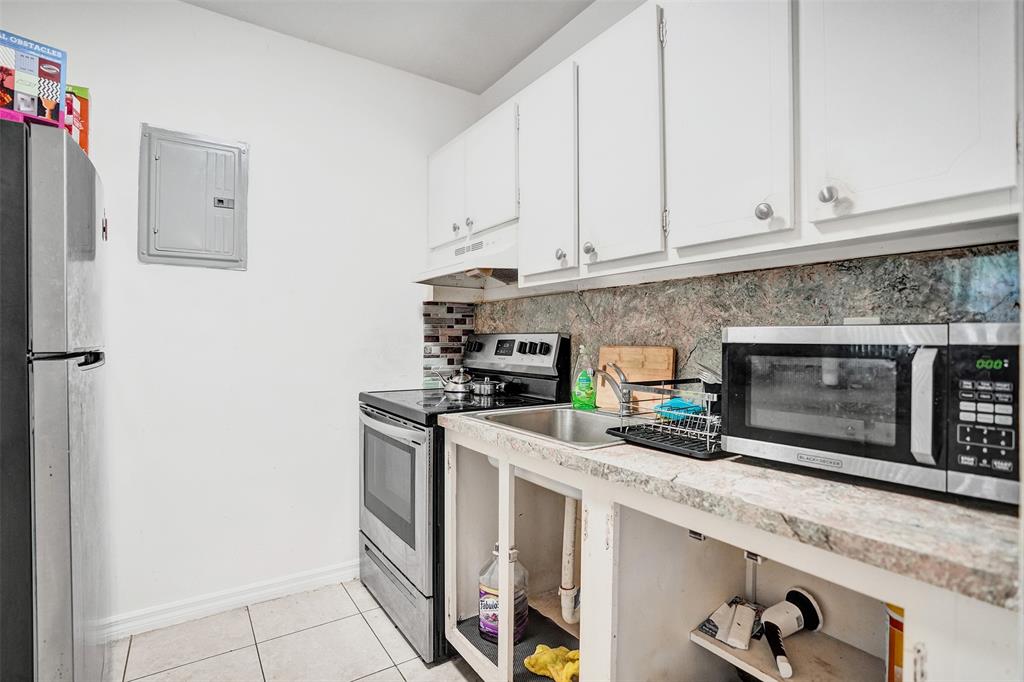2915 Plunkett Street, Unit 5D Hollywood, FL 33020 - Photo 7 of 11 a kitchen with stainless steel appliances granite countertop a stove a microwave and a refrigerator