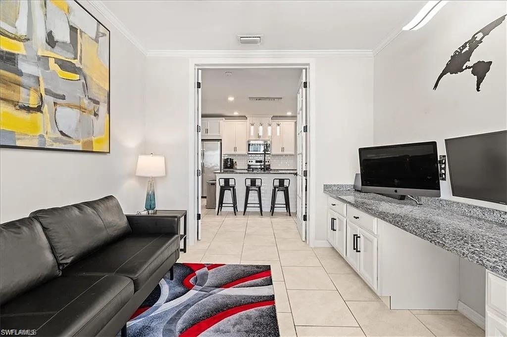 14672 Edgewater Circle Naples, FL 34114 - Photo 12 of 41 a living room with furniture and a flat screen tv