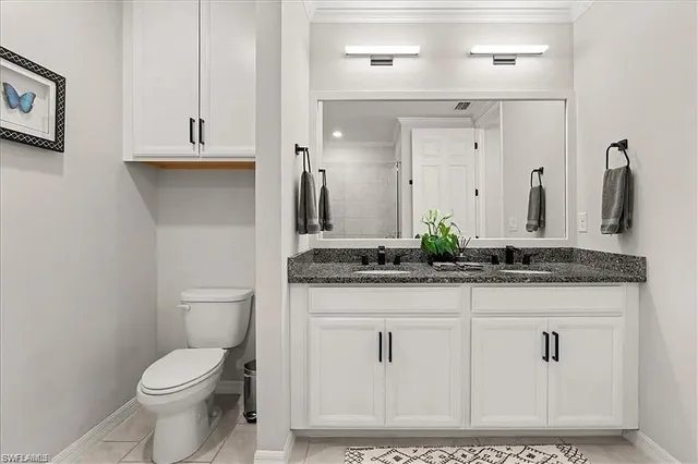 a bathroom with a granite countertop sink a toilet and a mirror