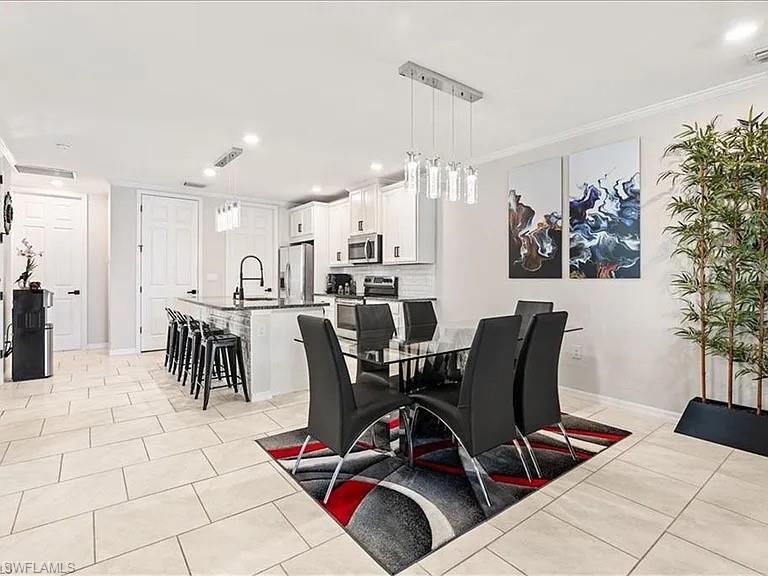 14672 Edgewater Circle Naples, FL 34114 - Photo 2 of 41 a view of a dining room with furniture and chandelier