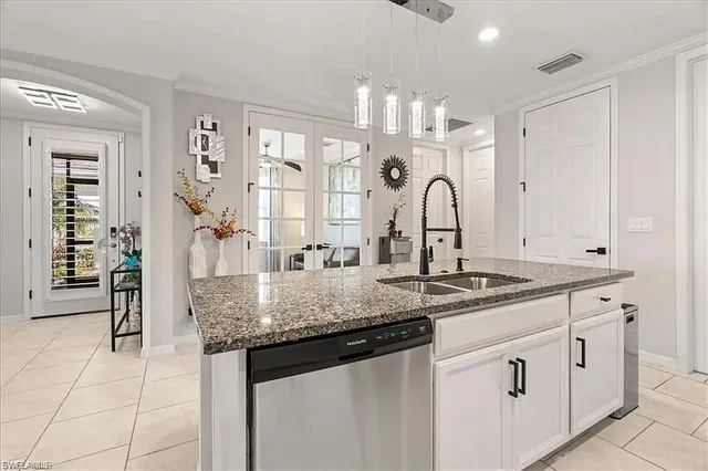 a kitchen with granite countertop a sink and white cabinets