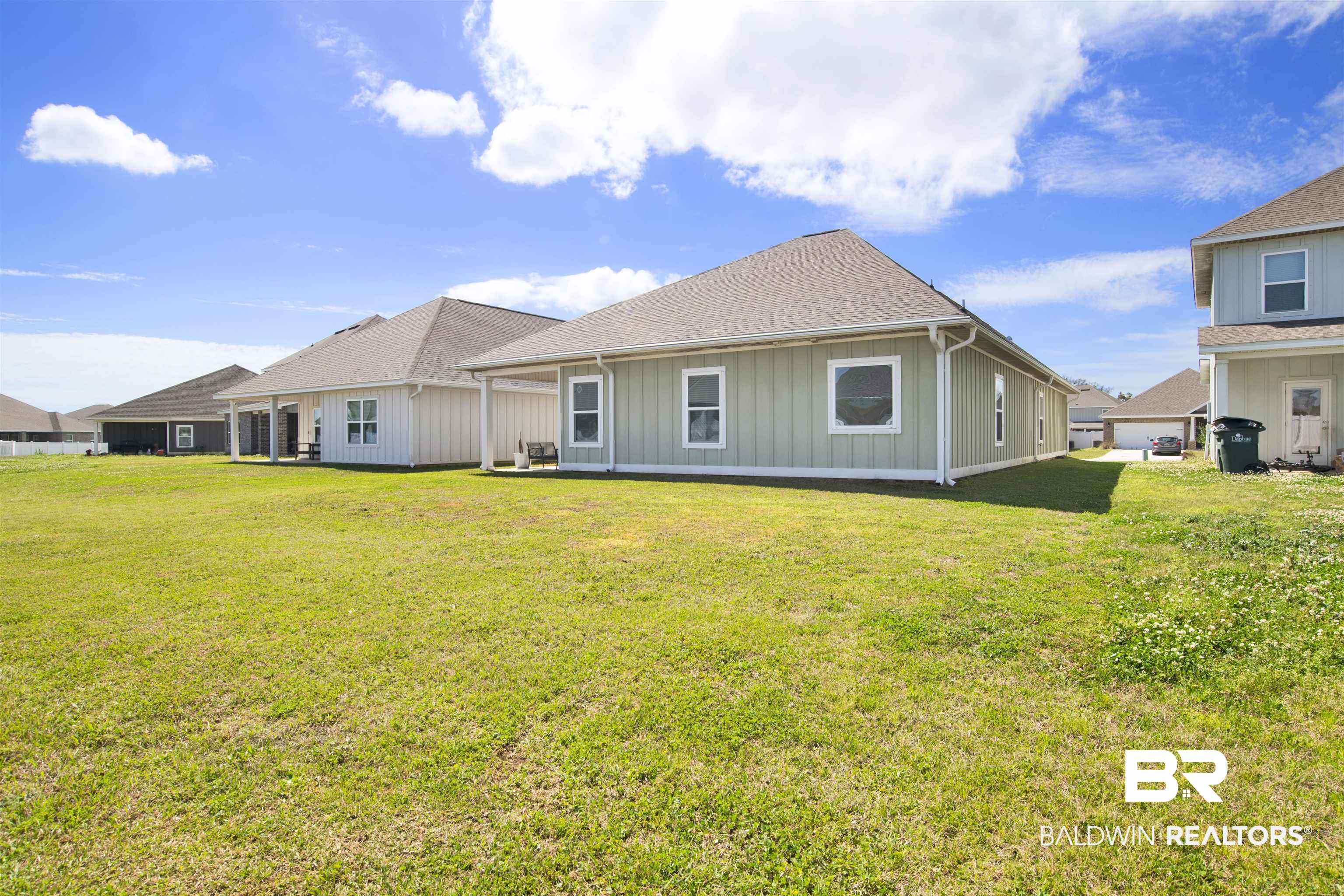 24253 Alydar Loop Daphne, AL 36526 - Photo 40 of 44 Rear view of house featuring a lawn, a patio, board and batten siding, and a shingled roof
