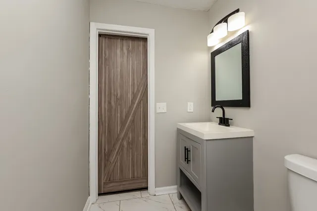 a bathroom with a toilet sink and mirror