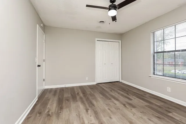 wooden floor in an empty room with a window