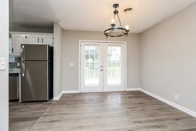 a view of empty room with wooden floor and window