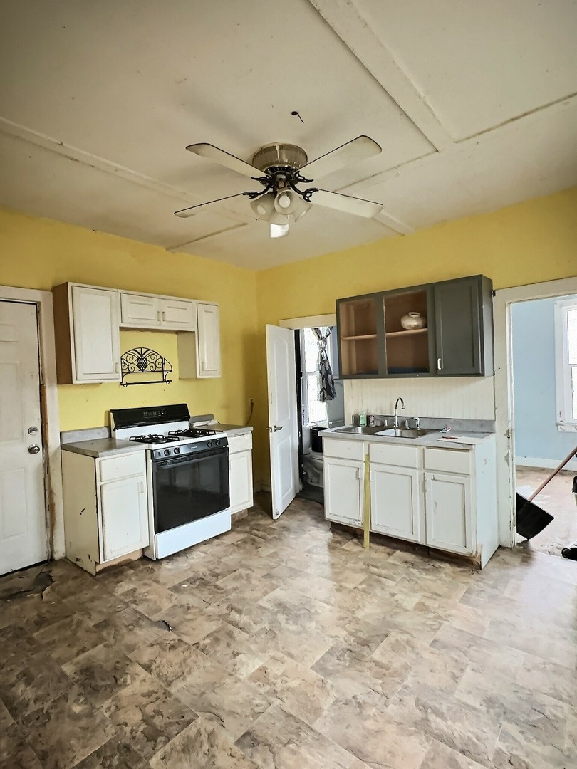 410 North 3rd Street Clinton, IA 52732 - Photo 5 of 8 a kitchen with a stove a microwave and a refrigerator