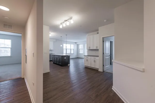 a view of a big room with wooden floor windows and a kitchen