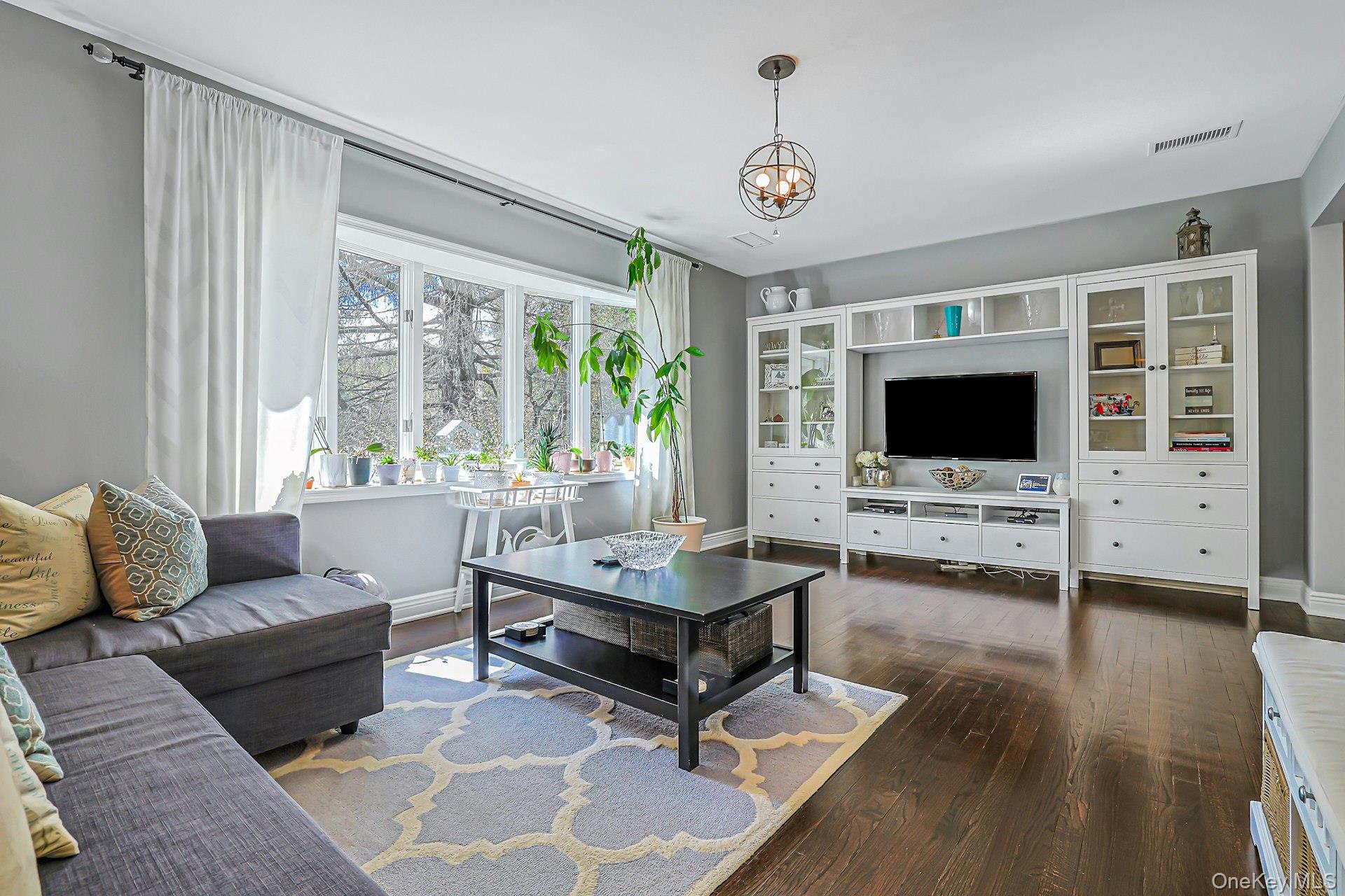 9 Stonegate Road Valhalla, NY 10595 - Photo 12 of 42 Hardwood flooring throughout, complemented by a large bay window, and a built-in media center with glass-front cabinetry