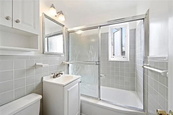 a bathroom with a sink mirror and a shower