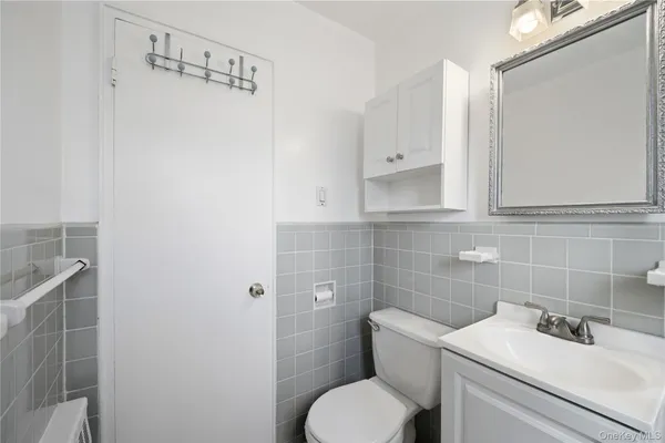 a bathroom with a toilet sink and mirror