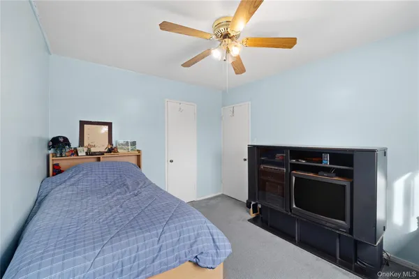 a bedroom with a bed and a ceiling fan