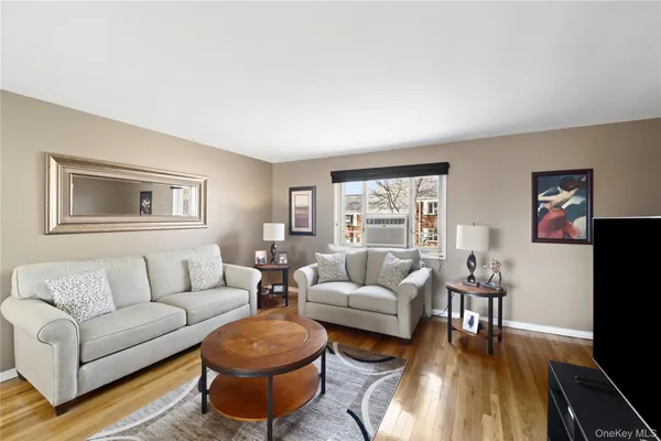a living room with furniture a rug a lamp and a window