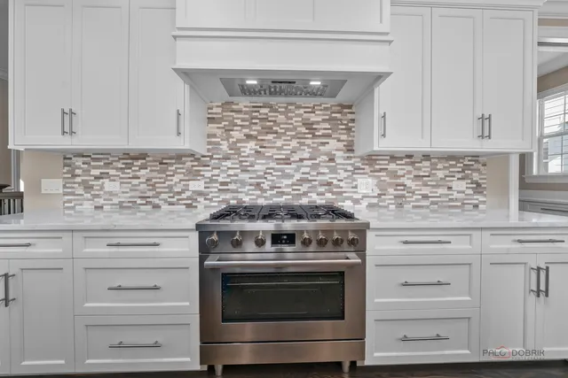 an empty room with wooden floor fireplace and windows