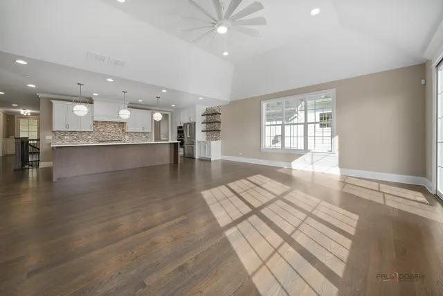 an empty room with windows and fireplace