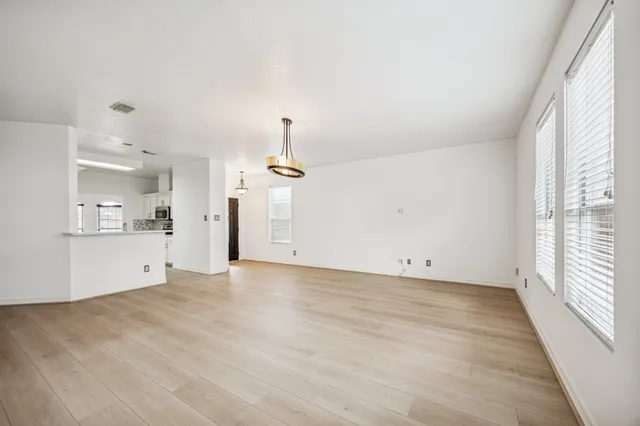 a view of empty room with wooden floor and window