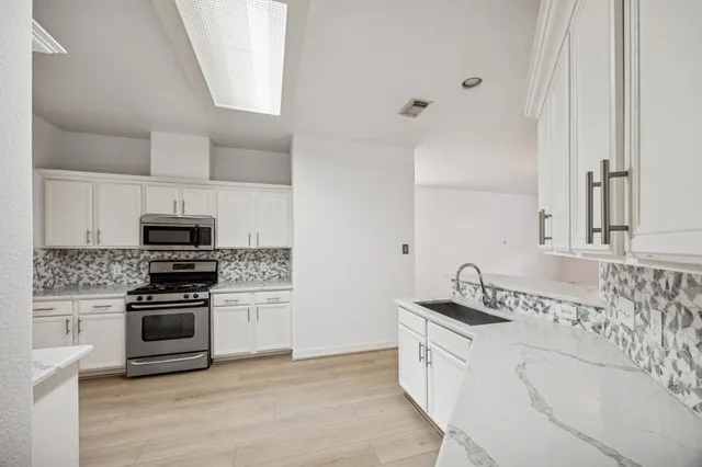 a kitchen with stainless steel appliances granite countertop a stove and a sink