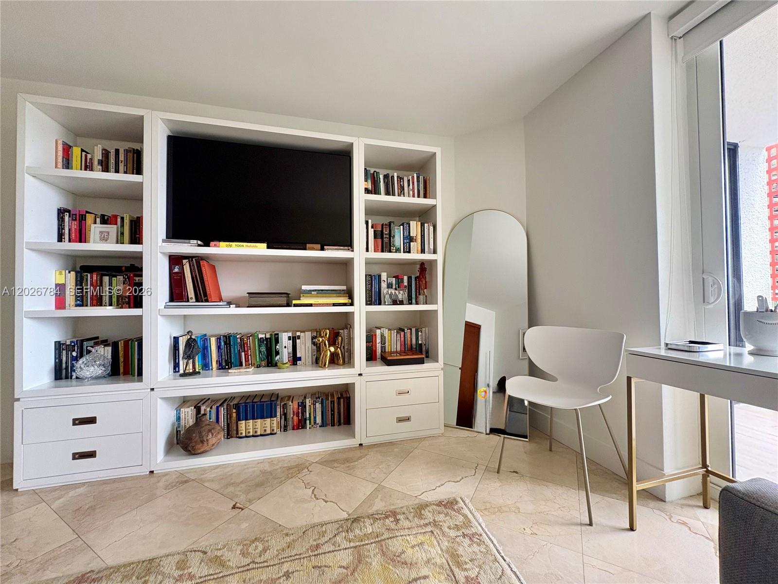 151 Southeast 15th Road, Unit 601 Miami, FL 33129 - Photo 27 of 36 a living room with furniture and a book shelf