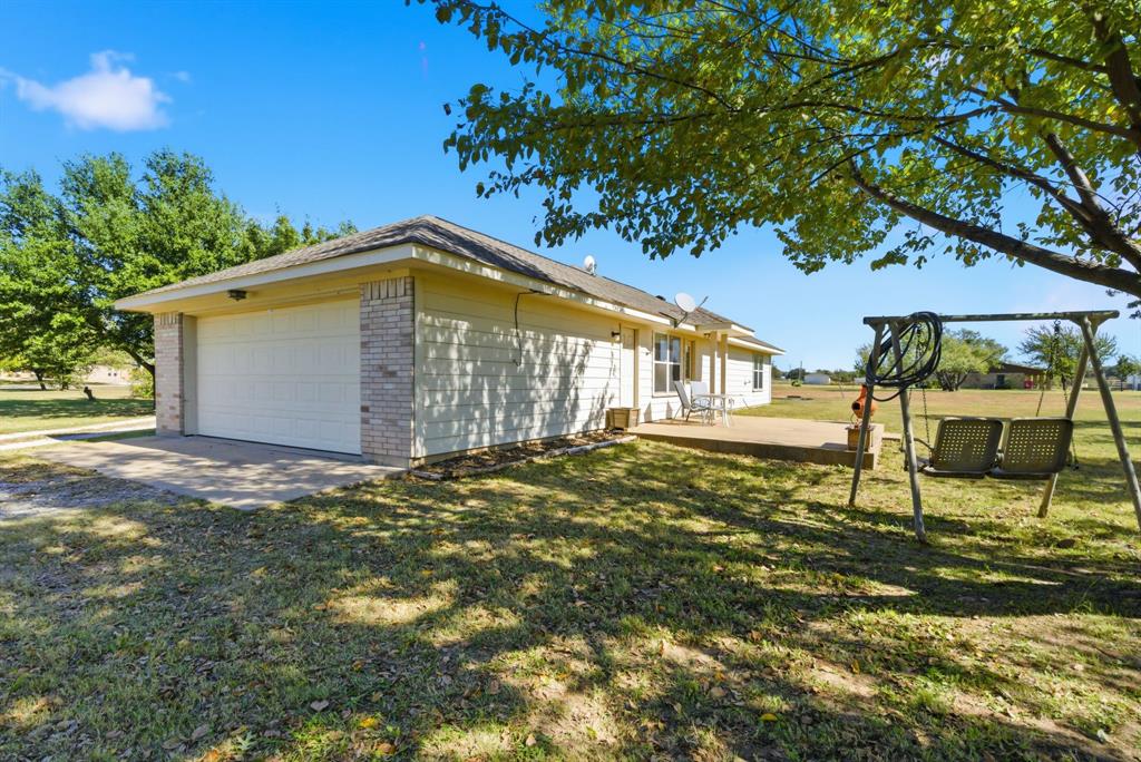 2710 Fairview Road Millsap, TX 76066 - Photo 25 of 40 a backyard of a house with table and chairs under an umbrella