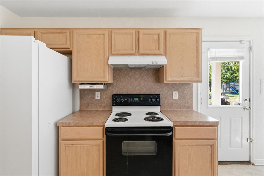 2710 Fairview Road Millsap, TX 76066 - Photo 10 of 40 a kitchen with a stove and a refrigerator