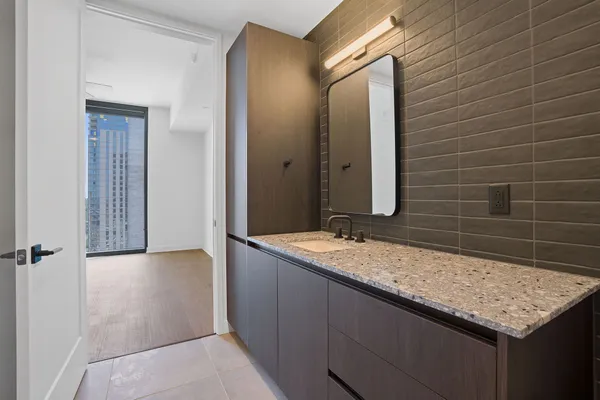 a bathroom with a granite countertop sink and a mirror