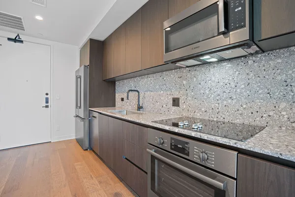 a kitchen with granite countertop a sink cabinets and stainless steel appliances