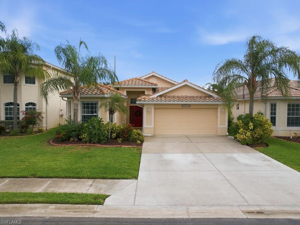 a front view of a house with a garden and palm trees