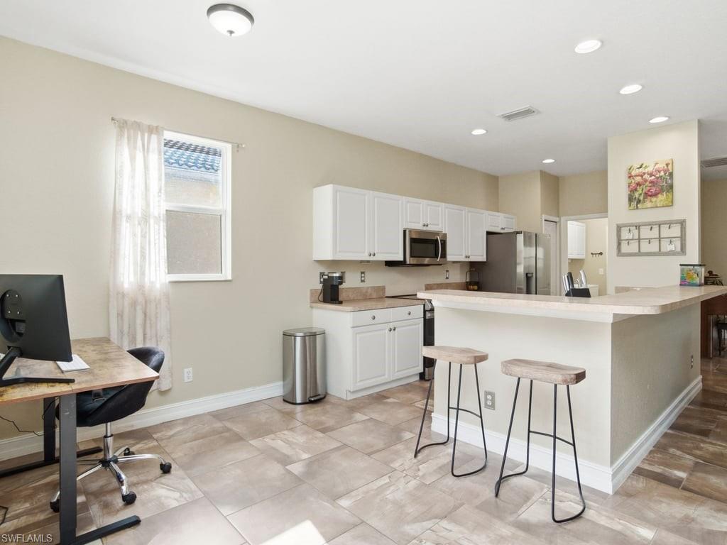 12719 Stone Tower Loop Fort Myers, FL 33913 - Photo 12 of 45 a kitchen with appliances cabinets and chair