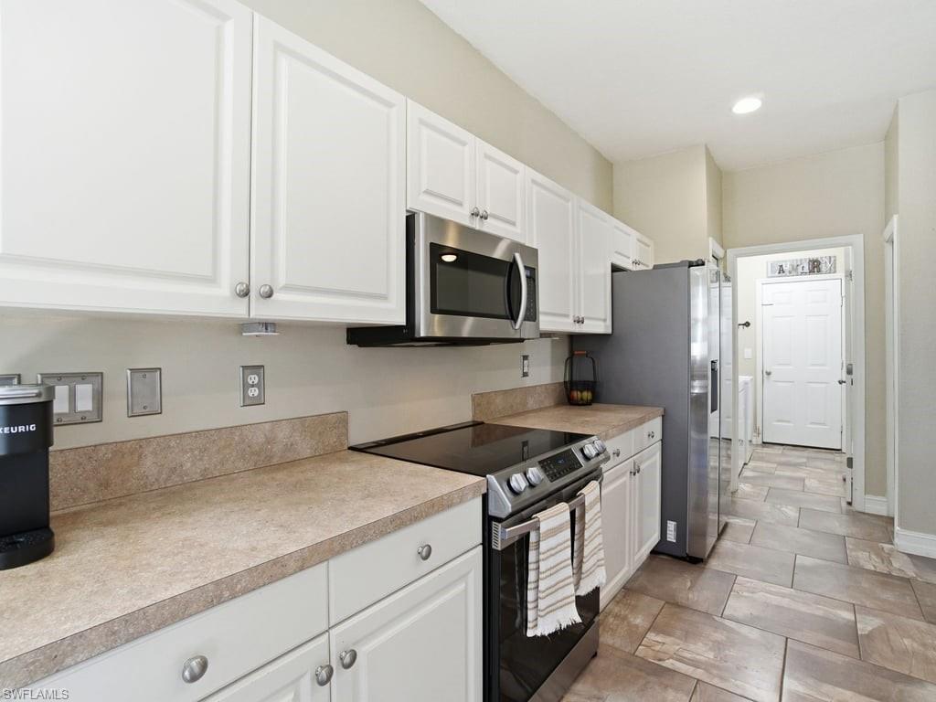 12719 Stone Tower Loop Fort Myers, FL 33913 - Photo 16 of 45 a kitchen with stainless steel appliances granite countertop a sink stove and refrigerator
