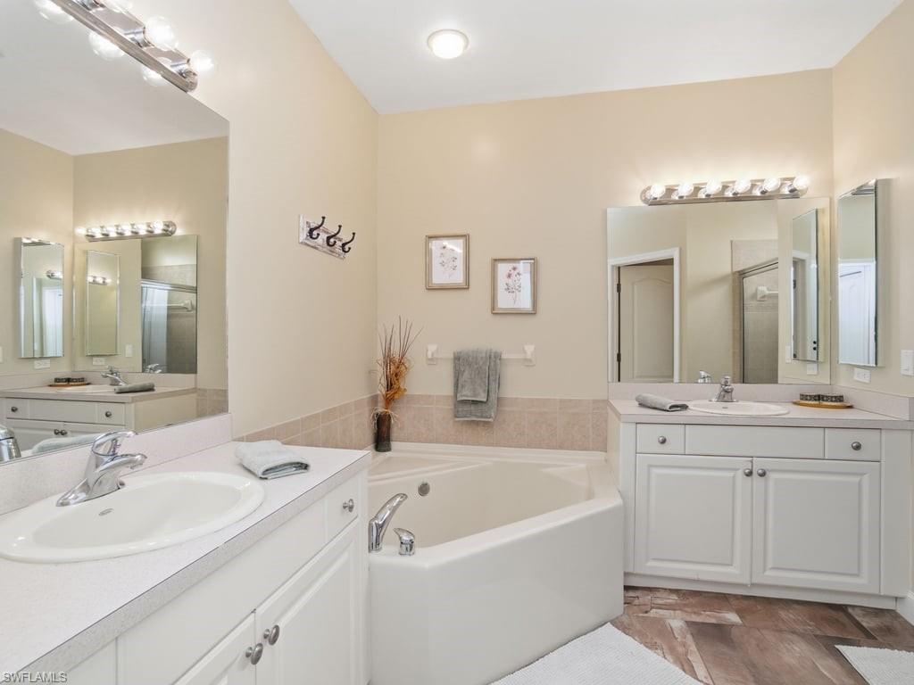 12719 Stone Tower Loop Fort Myers, FL 33913 - Photo 23 of 45 a bathroom with a tub a double vanity sink and mirror