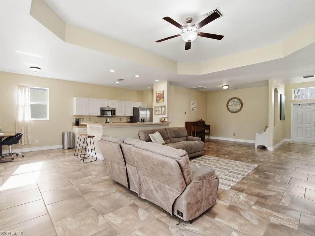 12719 Stone Tower Loop Fort Myers, FL 33913 - Photo 5 of 45 a living room with furniture a kitchen view and a chandelier