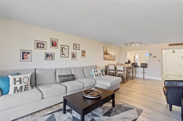 a living room with furniture and a dining table with wooden floor