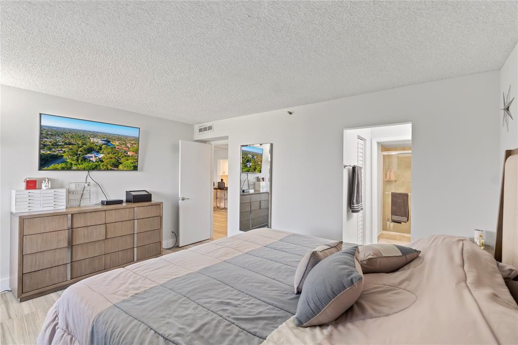 1850 Homewood Boulevard, Unit 512 Delray Beach, FL 33445 - Photo 18 of 43 a bedroom with a bed and a flat screen tv