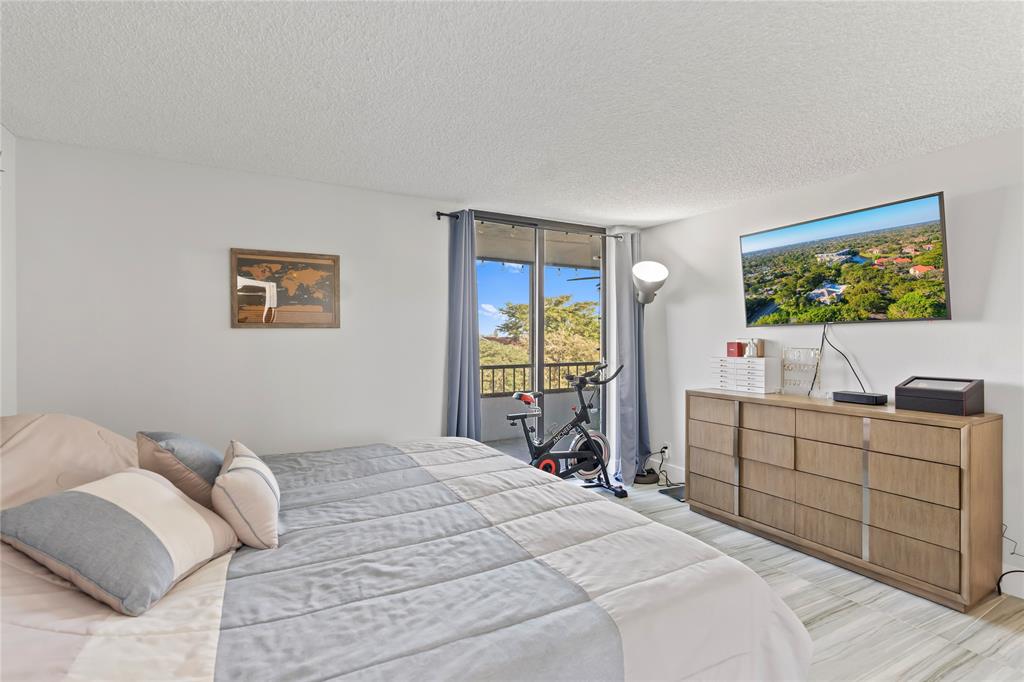 1850 Homewood Boulevard, Unit 512 Delray Beach, FL 33445 - Photo 19 of 43 a bedroom with a bed and a flat screen tv