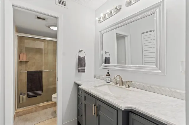 a bathroom with a granite countertop sink vanity and mirror