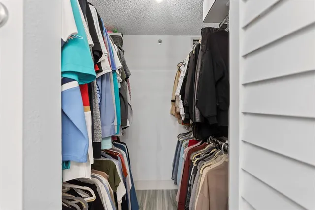 a view of walk in closet with clothes and shoes