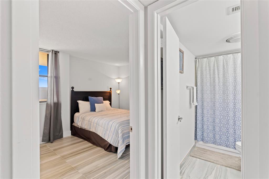 1850 Homewood Boulevard, Unit 512 Delray Beach, FL 33445 - Photo 3 of 43 a room with a bed and a mirror