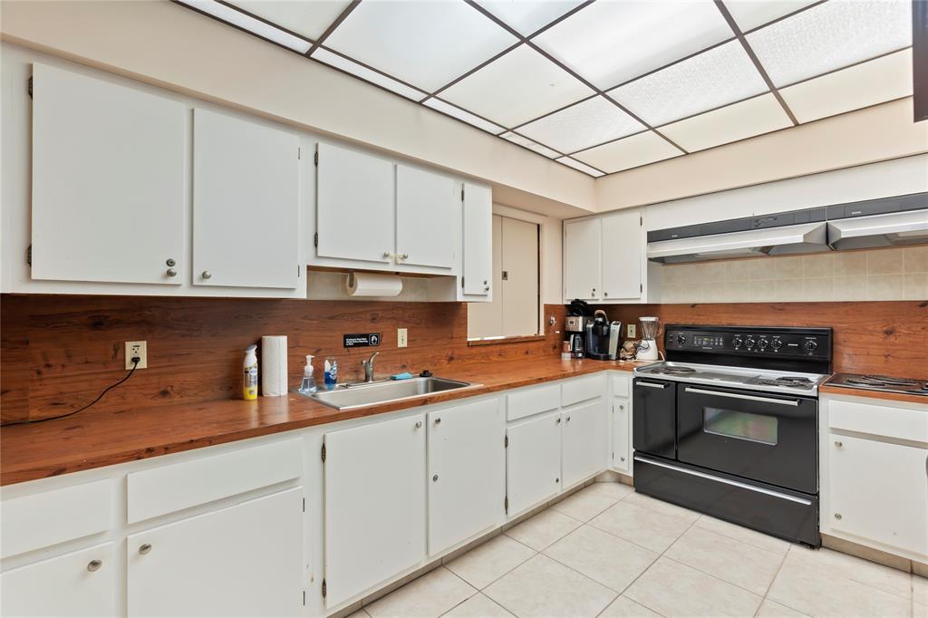 1850 Homewood Boulevard, Unit 512 Delray Beach, FL 33445 - Photo 33 of 43 a kitchen with granite countertop white cabinets stainless steel appliances and sink