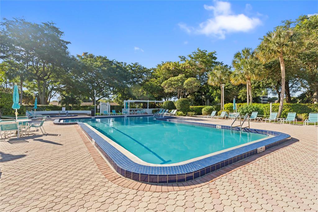 1850 Homewood Boulevard, Unit 512 Delray Beach, FL 33445 - Photo 34 of 43 a view of a swimming pool with a patio