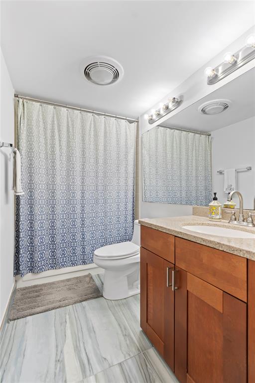 1850 Homewood Boulevard, Unit 512 Delray Beach, FL 33445 - Photo 5 of 43 a bathroom with a toilet a sink and a shower