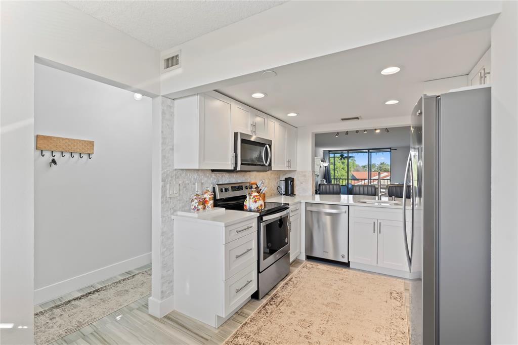1850 Homewood Boulevard, Unit 512 Delray Beach, FL 33445 - Photo 6 of 43 a kitchen with cabinets and stainless steel appliances
