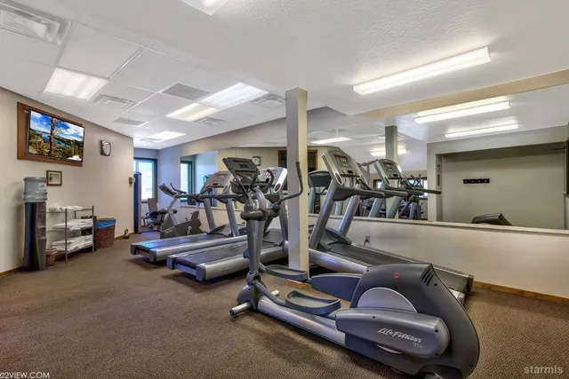a sign board with a yard and large trees