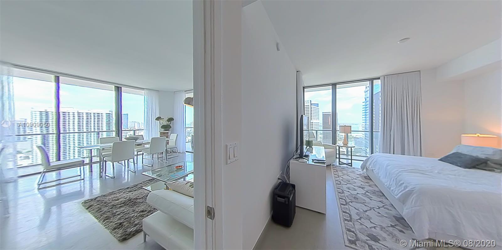 88 Southwest 7th Street, Unit 2911 Miami, FL 33130 - Photo 14 of 25 a bedroom with a large bed and glass window