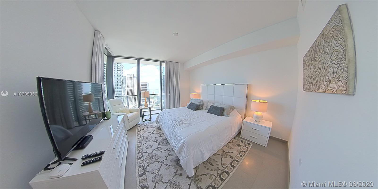 88 Southwest 7th Street, Unit 2911 Miami, FL 33130 - Photo 16 of 25 a bedroom with a bed a flat screen tv and a large window