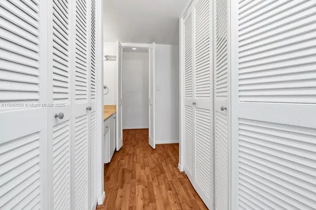 a view of a room that has a wooden floor and a window