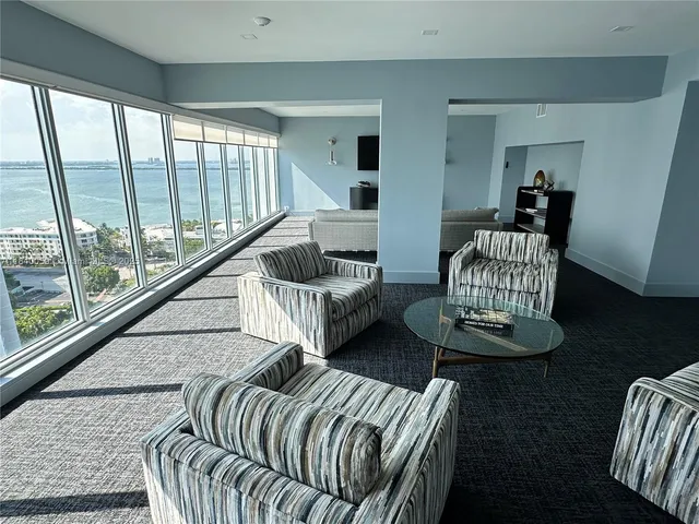 a living room with stainless steel appliances kitchen island granite countertop furniture wooden floor and a window