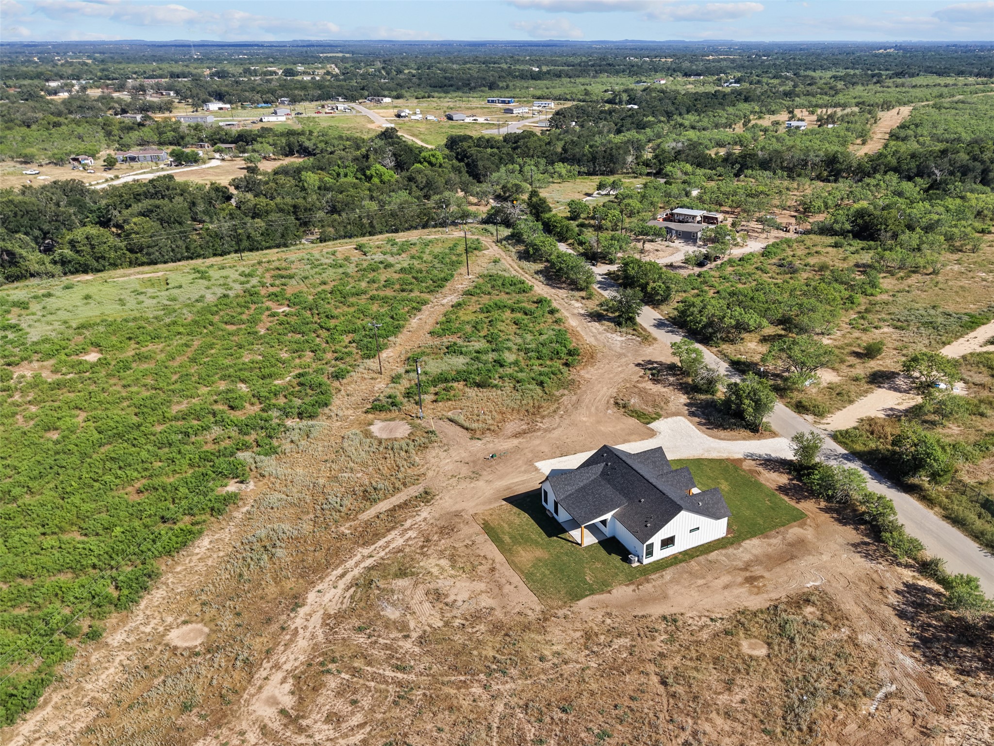 1420 Barth Road Dale, TX 78616 - Photo 36 of 37 An aerial perspective reveals a newly constructed dwelling amidst a natural, sprawling landscape.