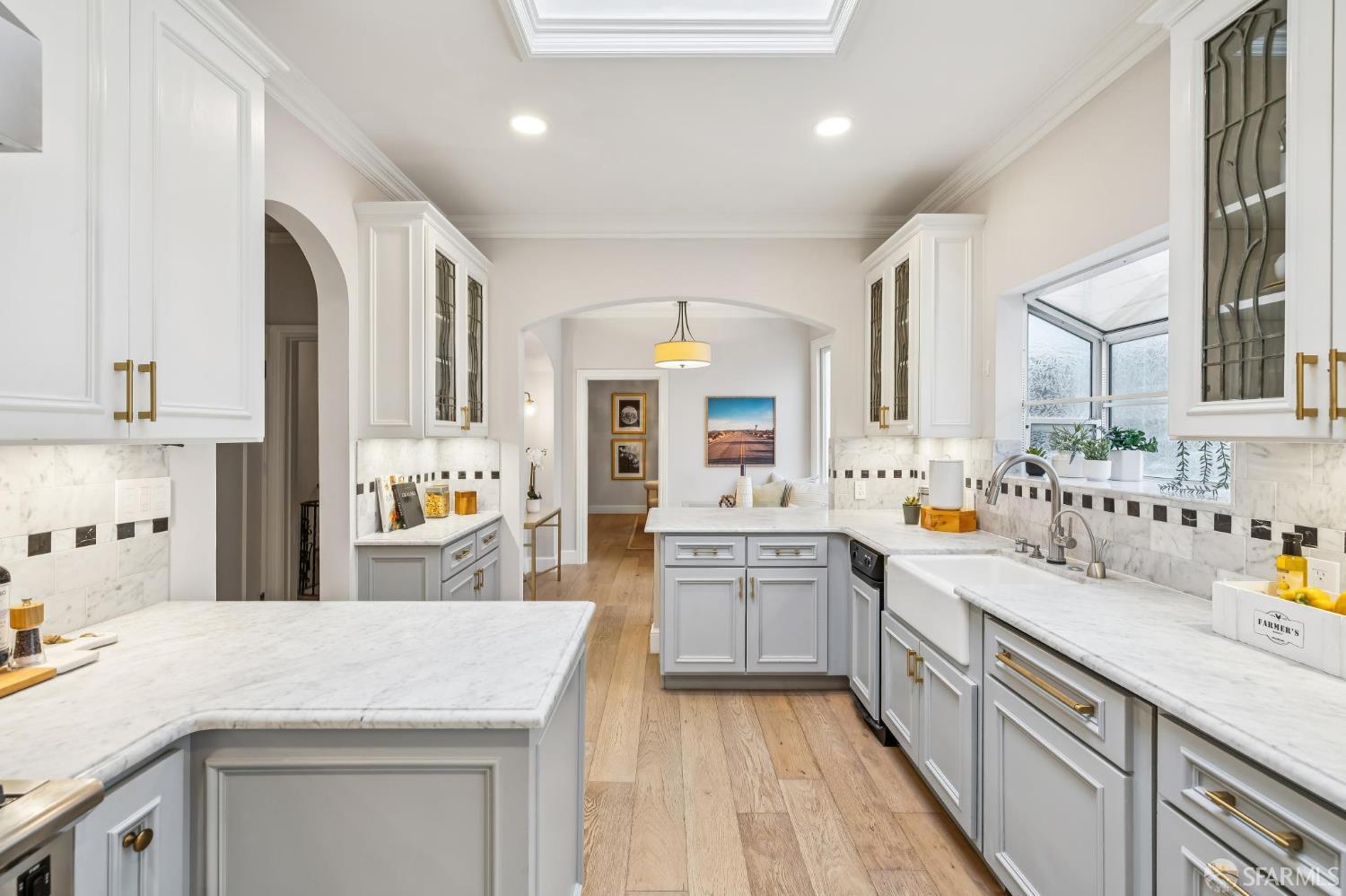 3641 Webster Street San Francisco, CA 94123 - Photo 29 of 52 a kitchen with stainless steel appliances kitchen island granite countertop a sink dishwasher stove and white cabinets with wooden floor